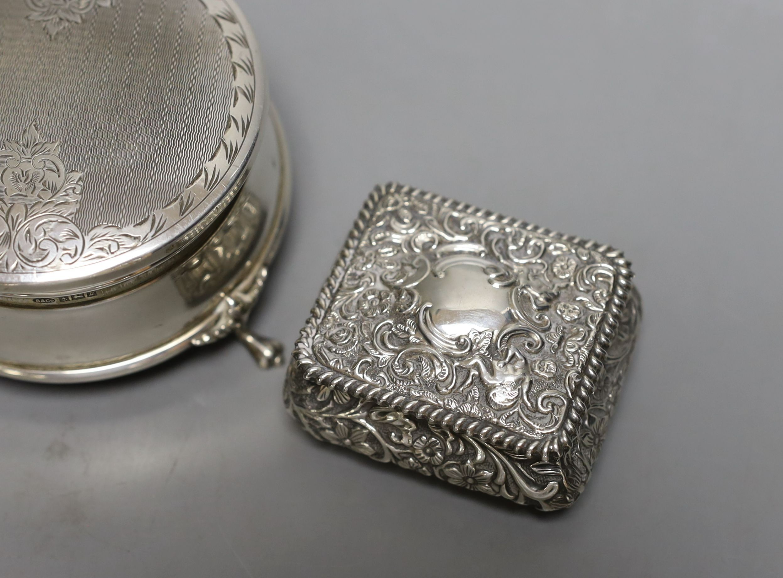 A modern silver mounted trinket box,82mm and two late Victorian embossed silver small boxes.